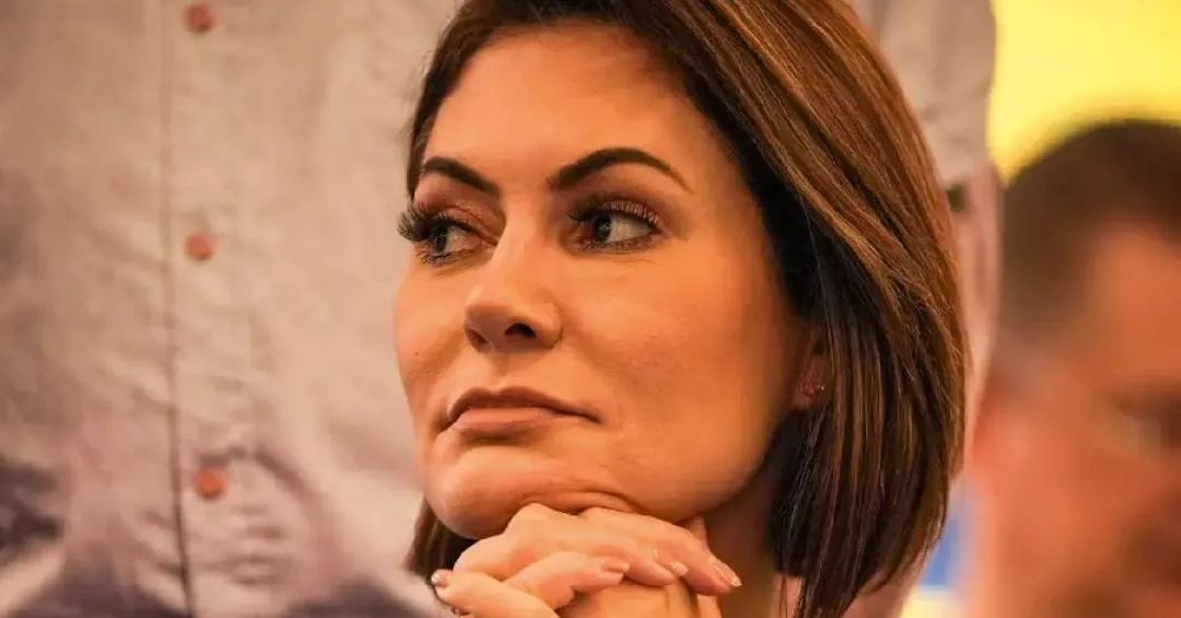 Michelle Bolsonaro diante de fundo azul do PL Mulher