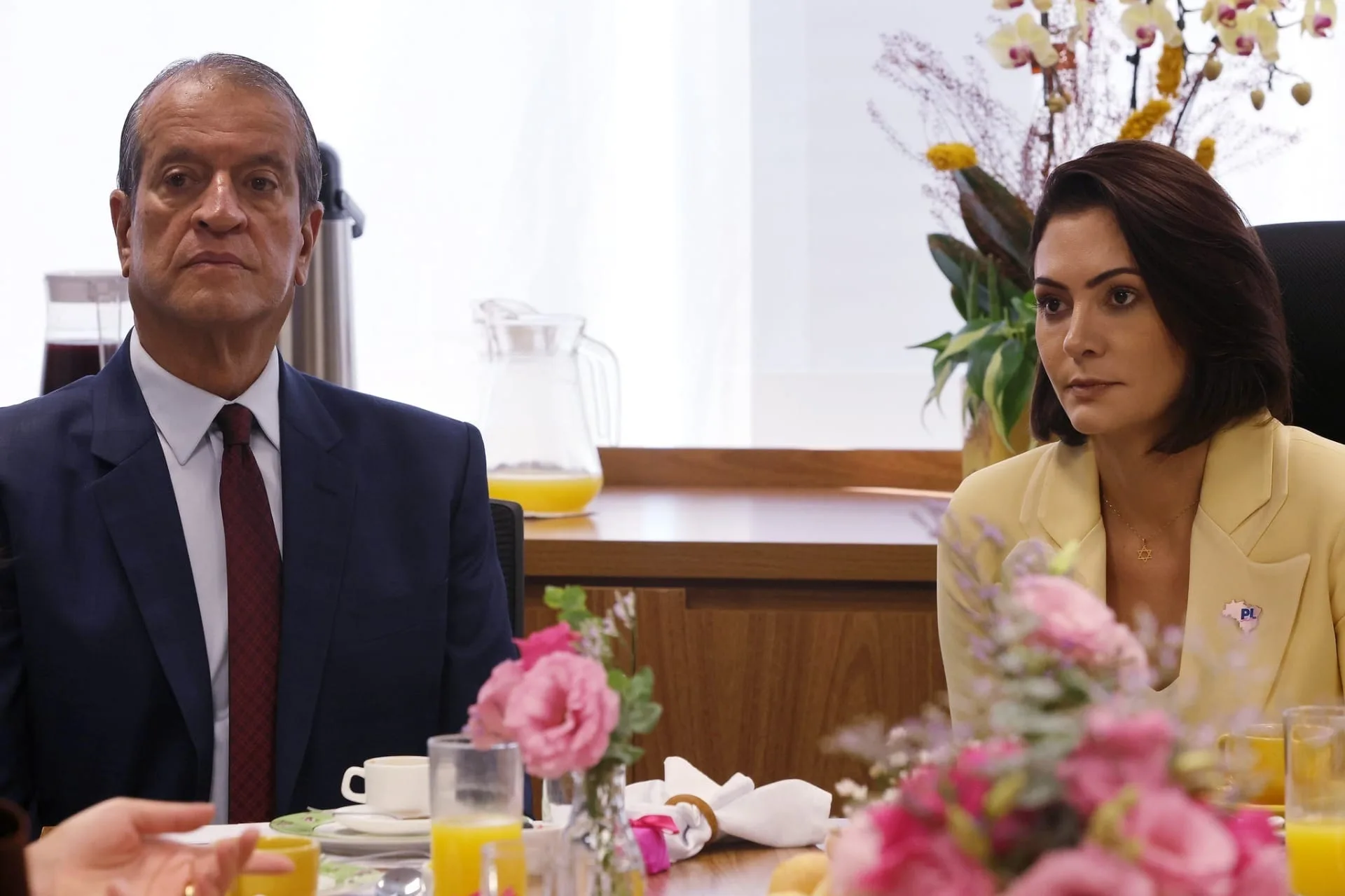 O presidente nacional do PL, Valdemar Costa Neto, e a ex-primeira-dama Michelle Bolsonaro, sentados, sérios