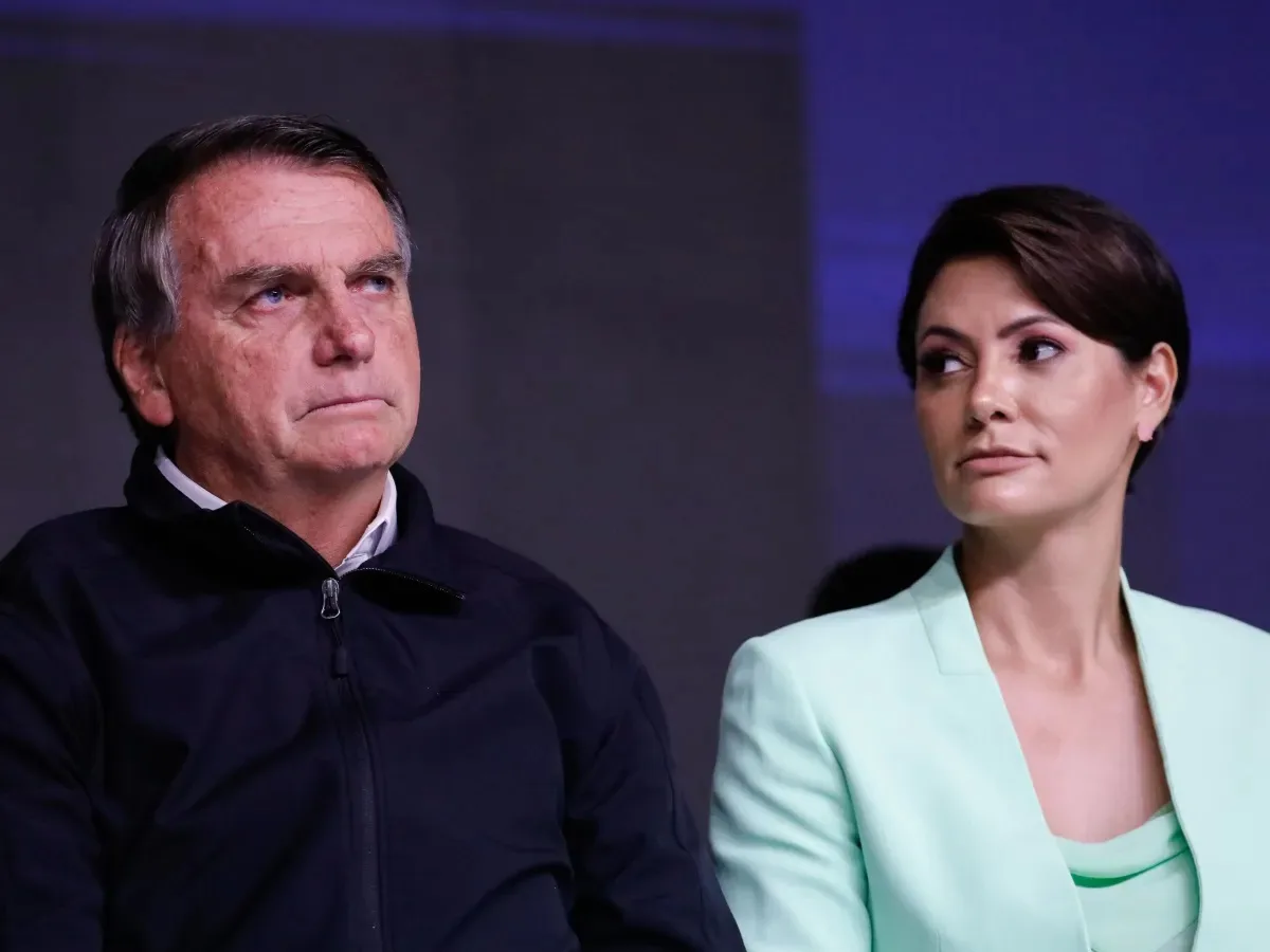 O ex-presidente Jair Bolsonaro (PL) e a ex-primeira-dama Michelle Bolsonaro (PL) sentados lado a lado, sérios
