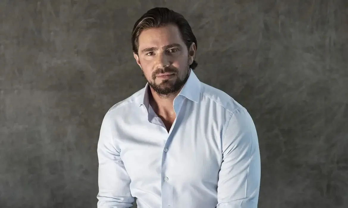 ex-banqueiro Daniel Vorcaro olhando para a câmera, sério, de camisa social clara