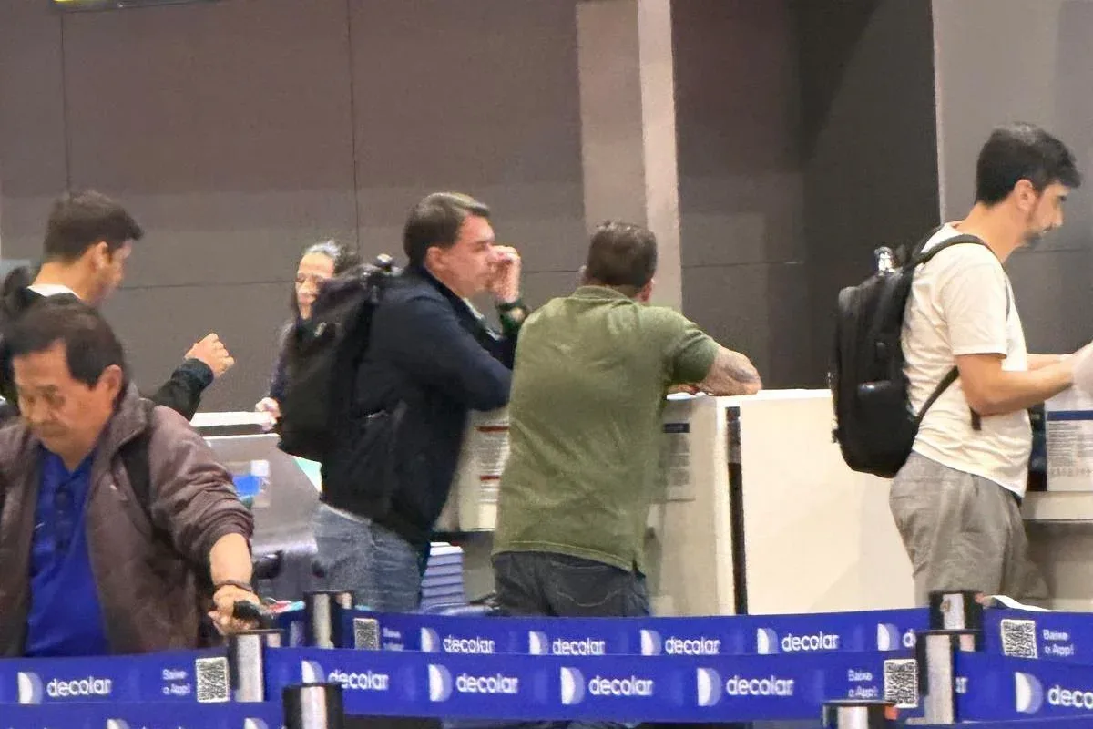 Flávio Bolsonaro em balcão de check-in no Aeroporto de Guarulhos